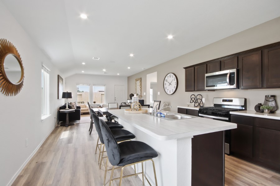 16903 Vinters Way Houston, TX 77090 - Photo 7 of 29 a kitchen with stainless steel appliances granite countertop a stove top oven a sink dishwasher and cabinets with wooden floor