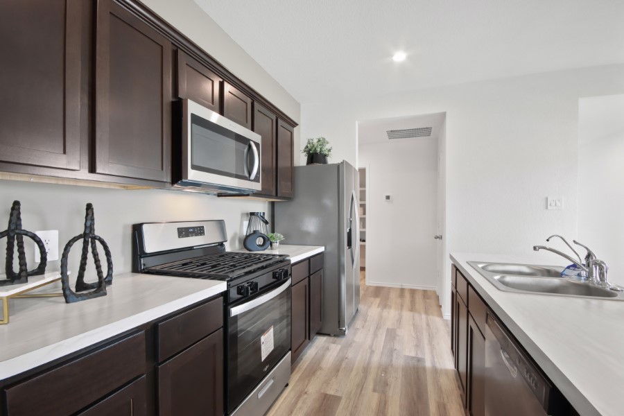 16903 Vinters Way Houston, TX 77090 - Photo 10 of 29 a kitchen with stainless steel appliances granite countertop a sink stove and refrigerator