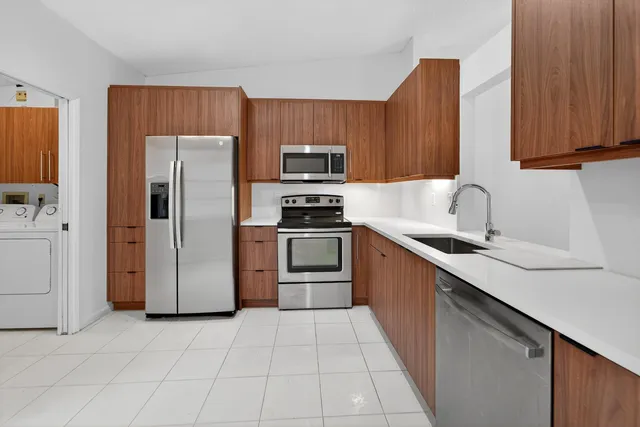 a kitchen with granite countertop a refrigerator and a sink