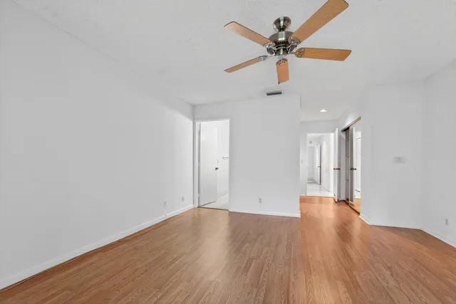 a view of an empty room with window and wooden floor