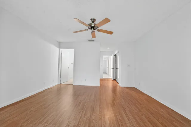 a view of empty room with wooden floor