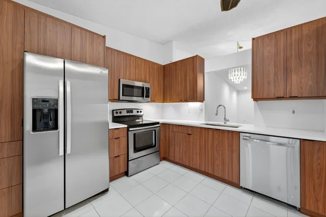 a kitchen with stainless steel appliances granite countertop a refrigerator stove a sink and dishwasher