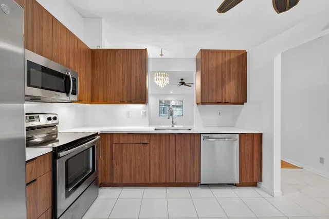 a kitchen with stainless steel appliances a stove microwave and sink