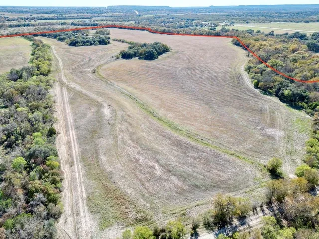 an aerial view of a house with a yard and ocean view