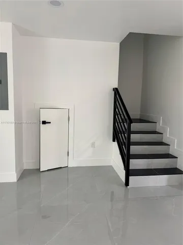 an empty room with stairs and white walls