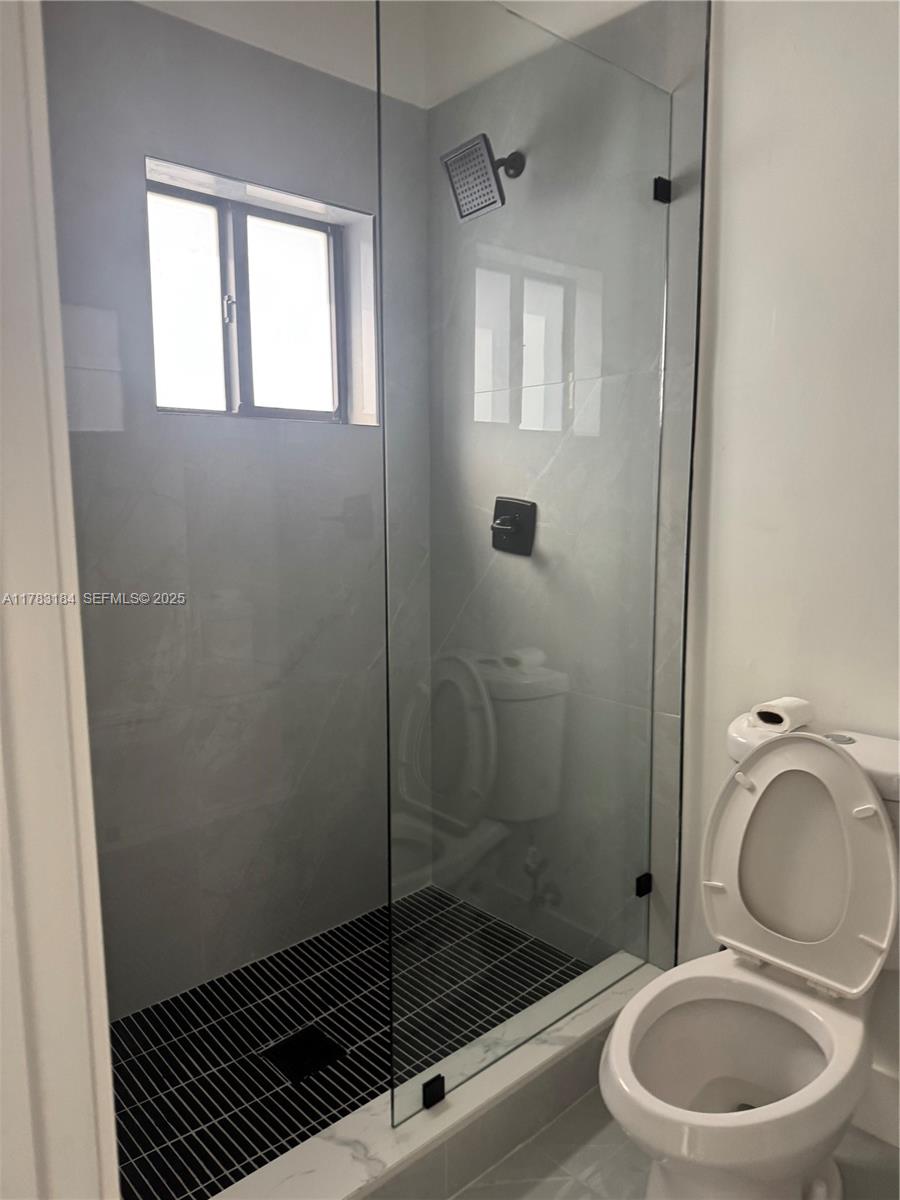 2970 Northwest 45th Street Miami, FL 33142 - Photo 9 of 26 a bathroom with a granite countertop toilet a sink and a shower