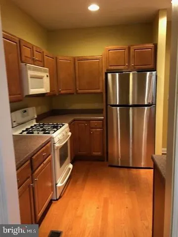 a kitchen with a refrigerator a stove a sink and cabinets