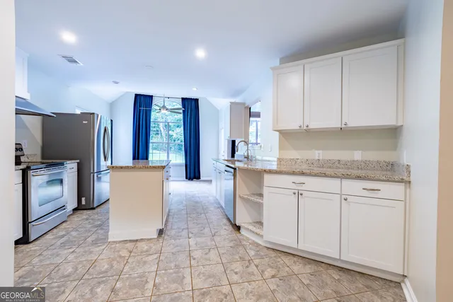 a kitchen with granite countertop cabinets sink and window