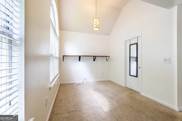 a bedroom with a bed and a flat tv screen on dresser