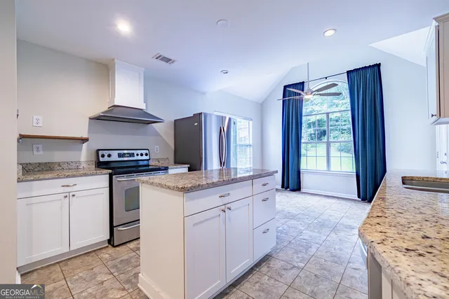 a kitchen with stainless steel appliances granite countertop a stove a sink and a refrigerator