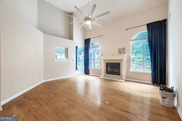 an empty room with windows and fireplace