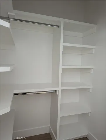 a view of walk in closet with empty racks