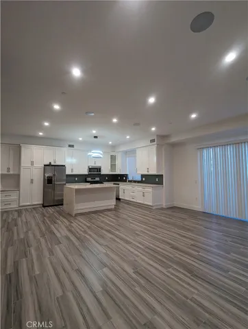 a view of kitchen with kitchen island and stainless steel appliances