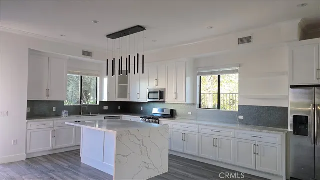 a kitchen with granite countertop a sink window and cabinets