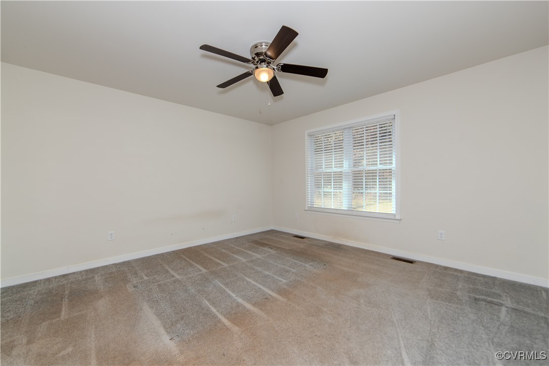 14671 Baltimore Road Dewitt, VA 23840 - Photo 13 of 27 an empty room with ceiling fan and windows