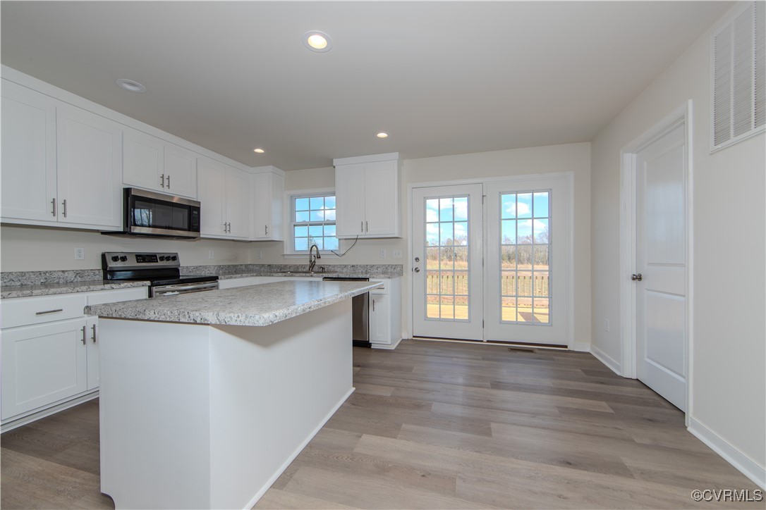 14671 Baltimore Road Dewitt, VA 23840 - Photo 4 of 27 a large kitchen with stainless steel appliances granite countertop a stove a sink dishwasher and a microwave oven with white cabinets