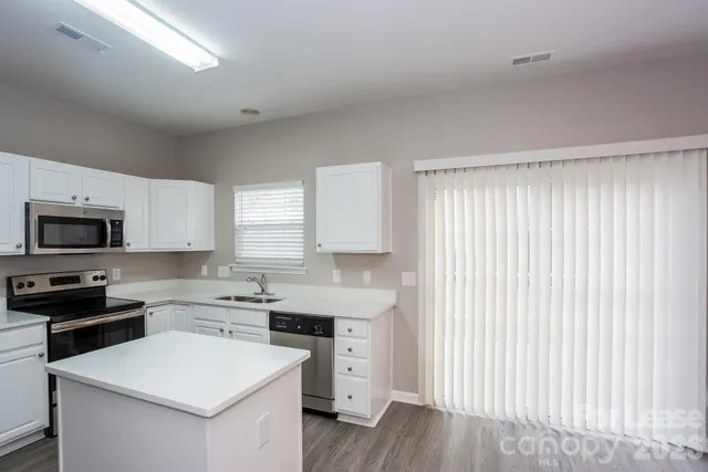 a kitchen with a stove a sink and a microwave