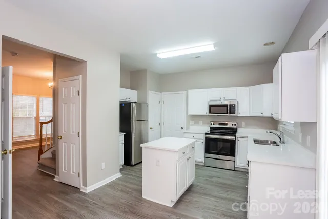 a kitchen with stainless steel appliances a refrigerator sink and stove