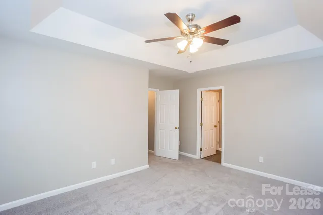 an empty room with closet and ceiling fan