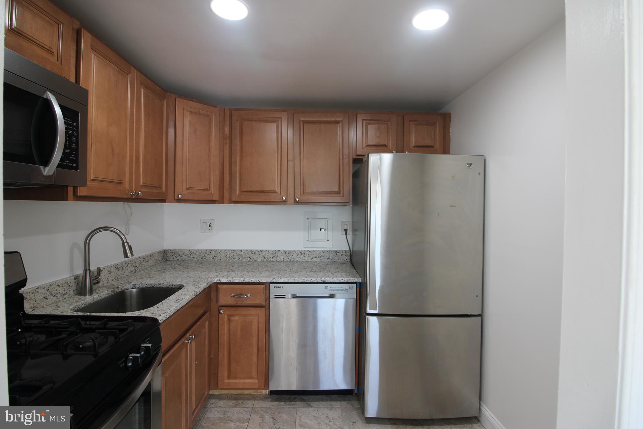 a kitchen with a refrigerator sink and cabinets