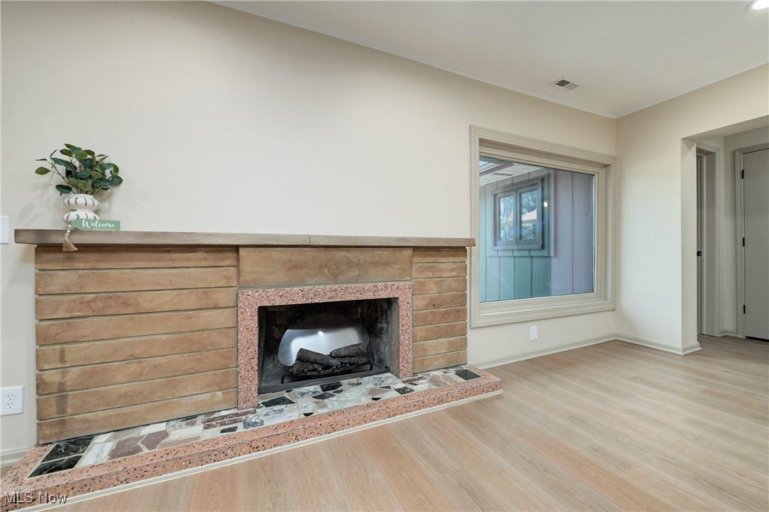 433 Chestnut Road Independence, OH 44131 - Photo 10 of 50 Unfurnished living room featuring a brick fireplace and wood finished floors