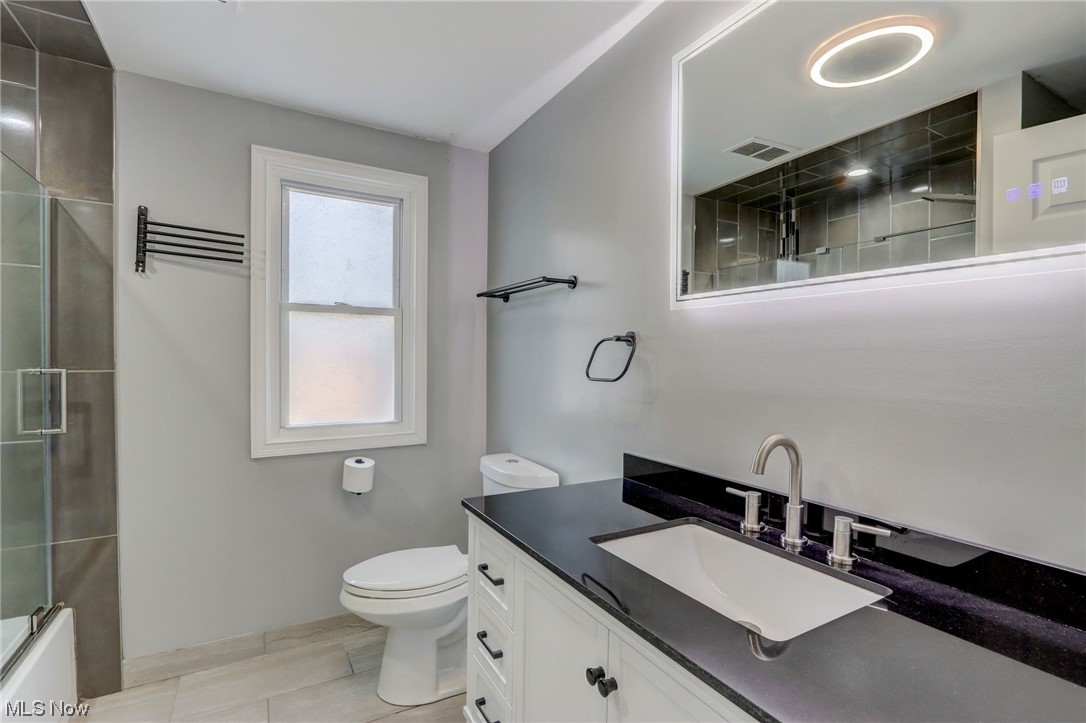 19480 Drake Road Strongsville, OH 44149 - Photo 20 of 39 Full bathroom with combined bath / shower with glass door, vanity, tile floors, and toilet