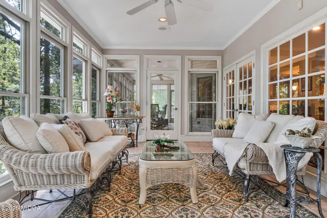 a view of a room that has a large window and front view of a house