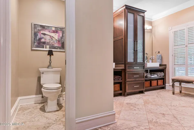 a bedroom with a bed and a lamp on dresser