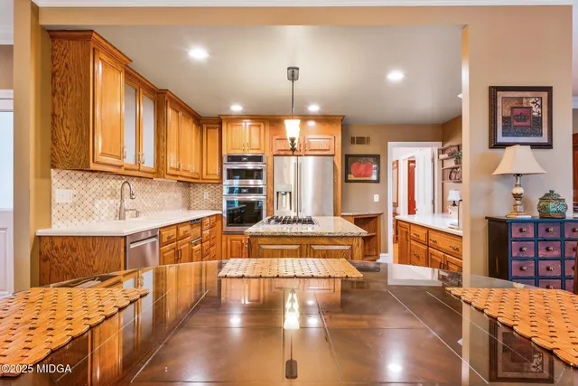 a kitchen with stainless steel appliances granite countertop a sink a stove and a refrigerator
