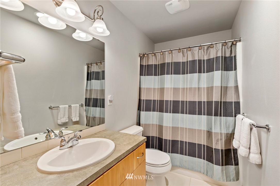 130 Cougar Ridge Road Northwest, Unit 1502 Issaquah, WA 98027 - Photo 22 of 28 a bathroom with a sink a toilet a shower and a mirror