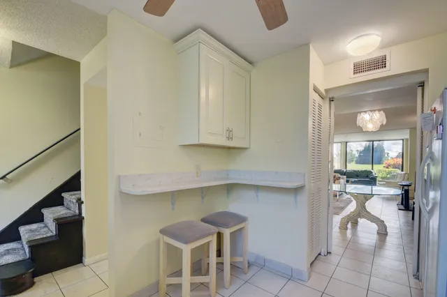 a kitchen with a sink and chairs