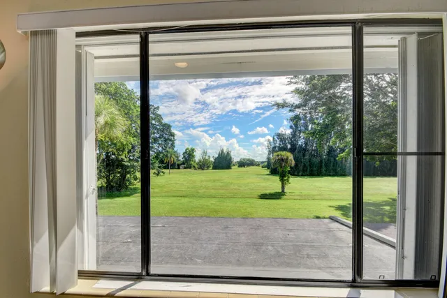 a view of a room with a large window and front door