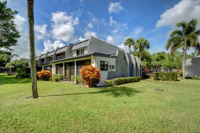 a view of a house with a yard and potted plants
