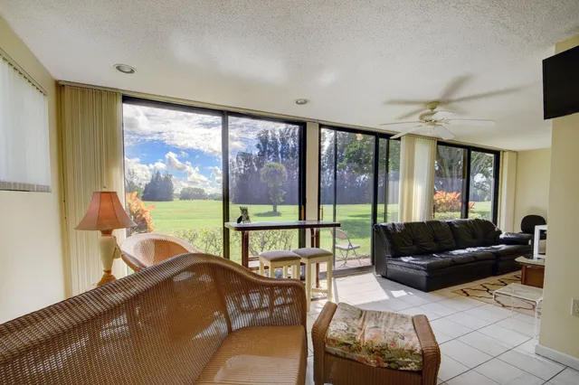 a living room with furniture and a floor to ceiling window