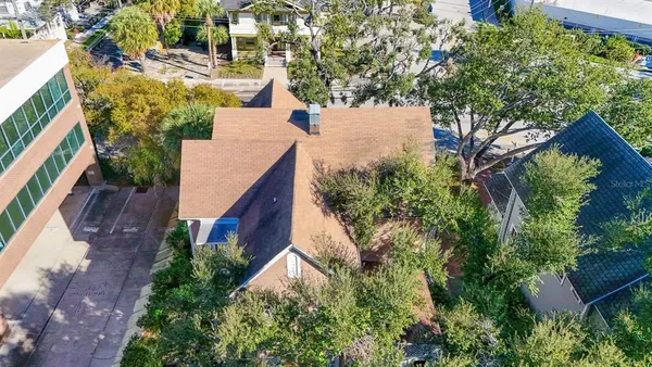 an aerial view of residential house with outdoor space and trees all around