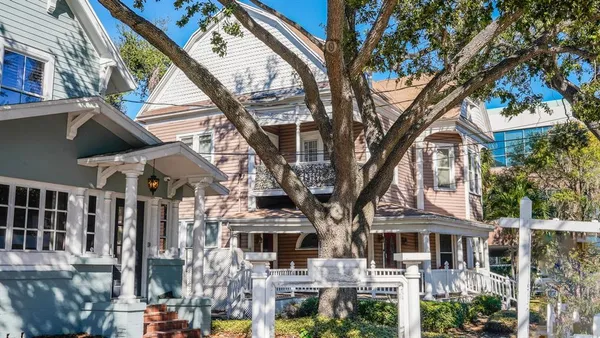 a front view of a building with a tree