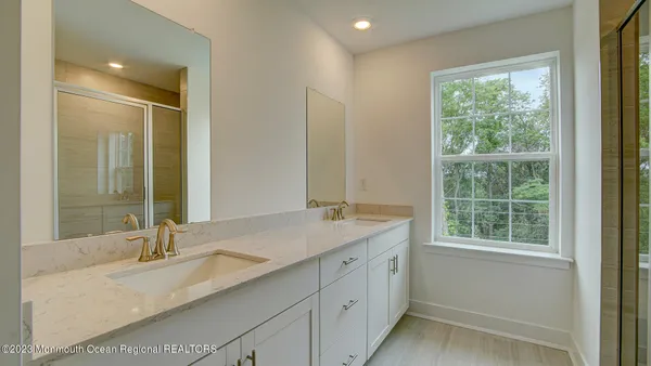 a bathroom with a granite countertop sink mirror and a window