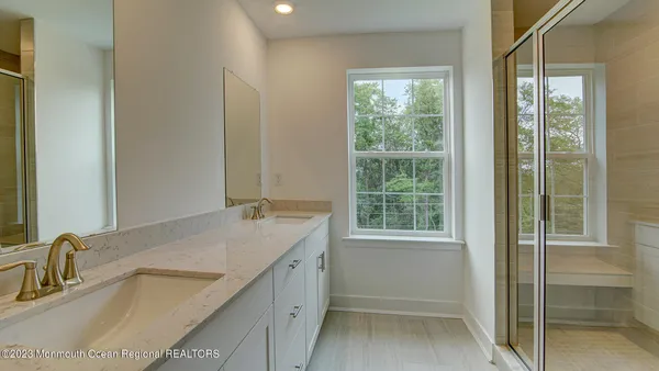 a bathroom with a granite countertop sink and a window