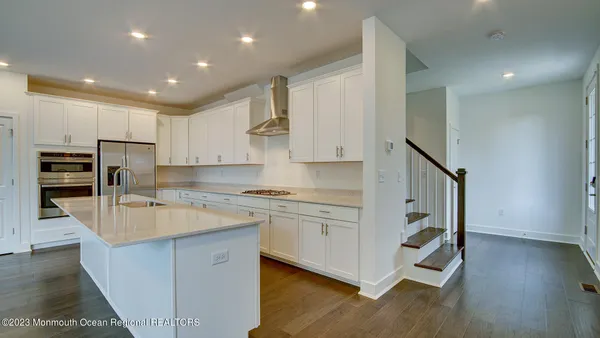 a kitchen with kitchen island sink stove and cabinets