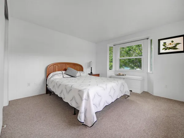 a bed sitting in a bedroom next to a window