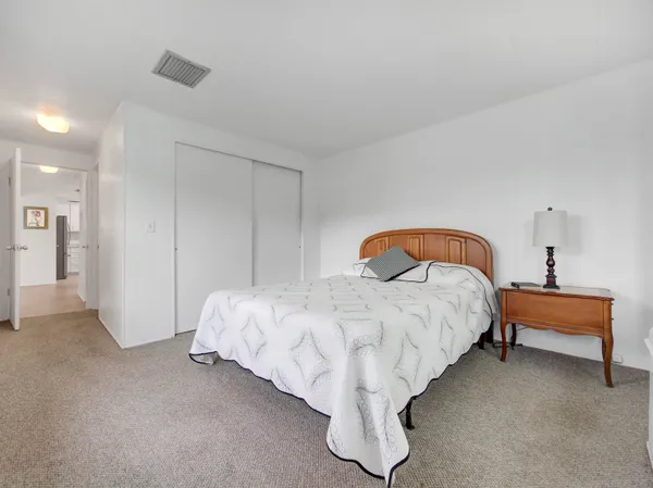a bed sitting in a bedroom next to a lamp