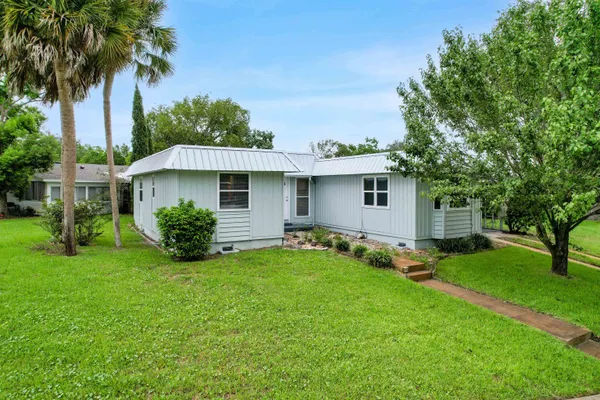 a view of a house with a yard and sitting area