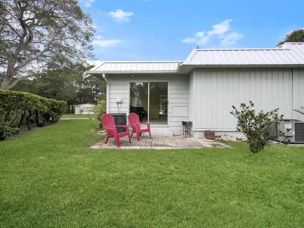 a view of a house with backyard sitting area and garden