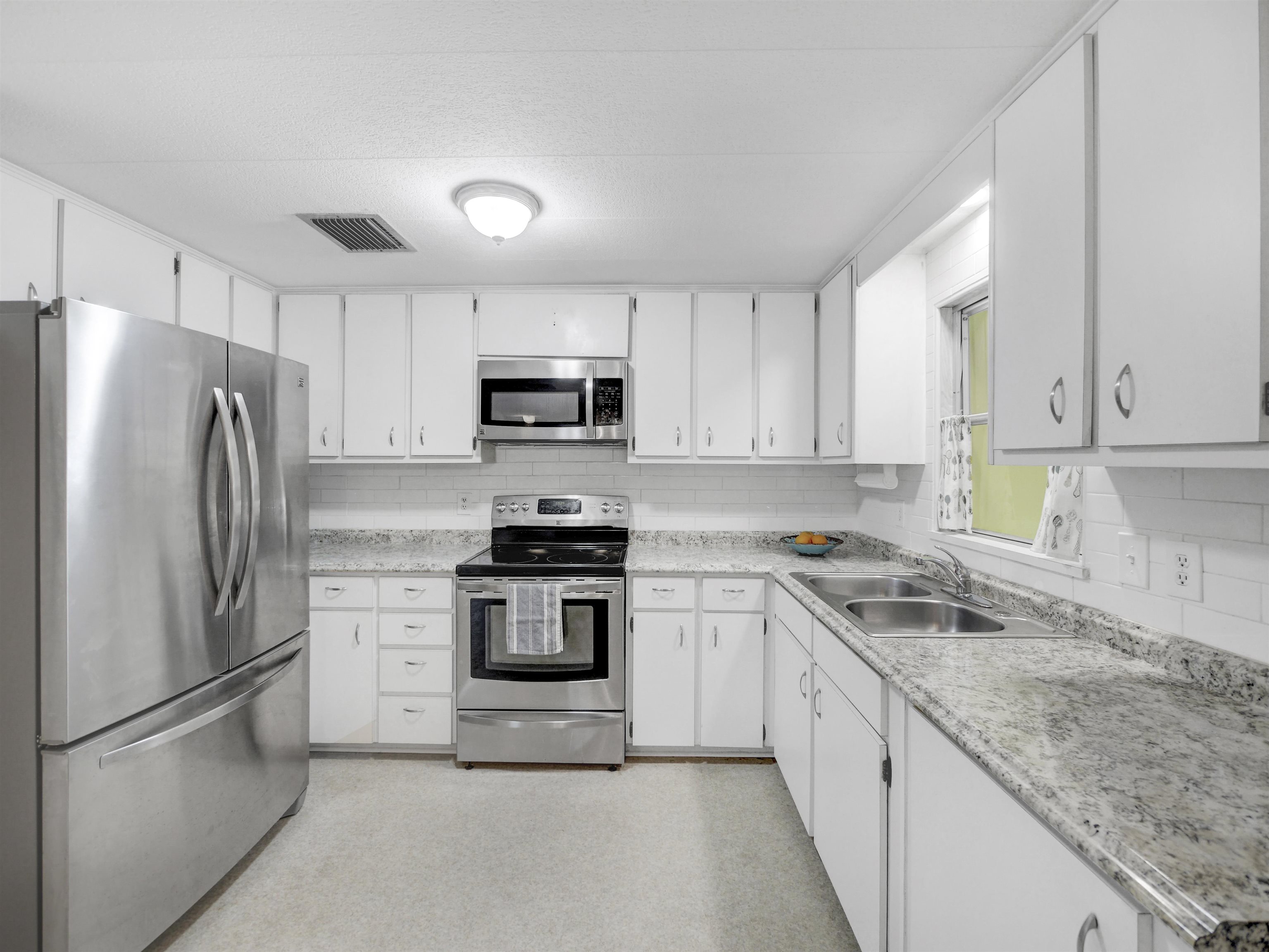 879 Palermo Road St. Augustine, FL 32086 - Photo 8 of 38 a kitchen with stainless steel appliances granite countertop a refrigerator stove microwave and sink