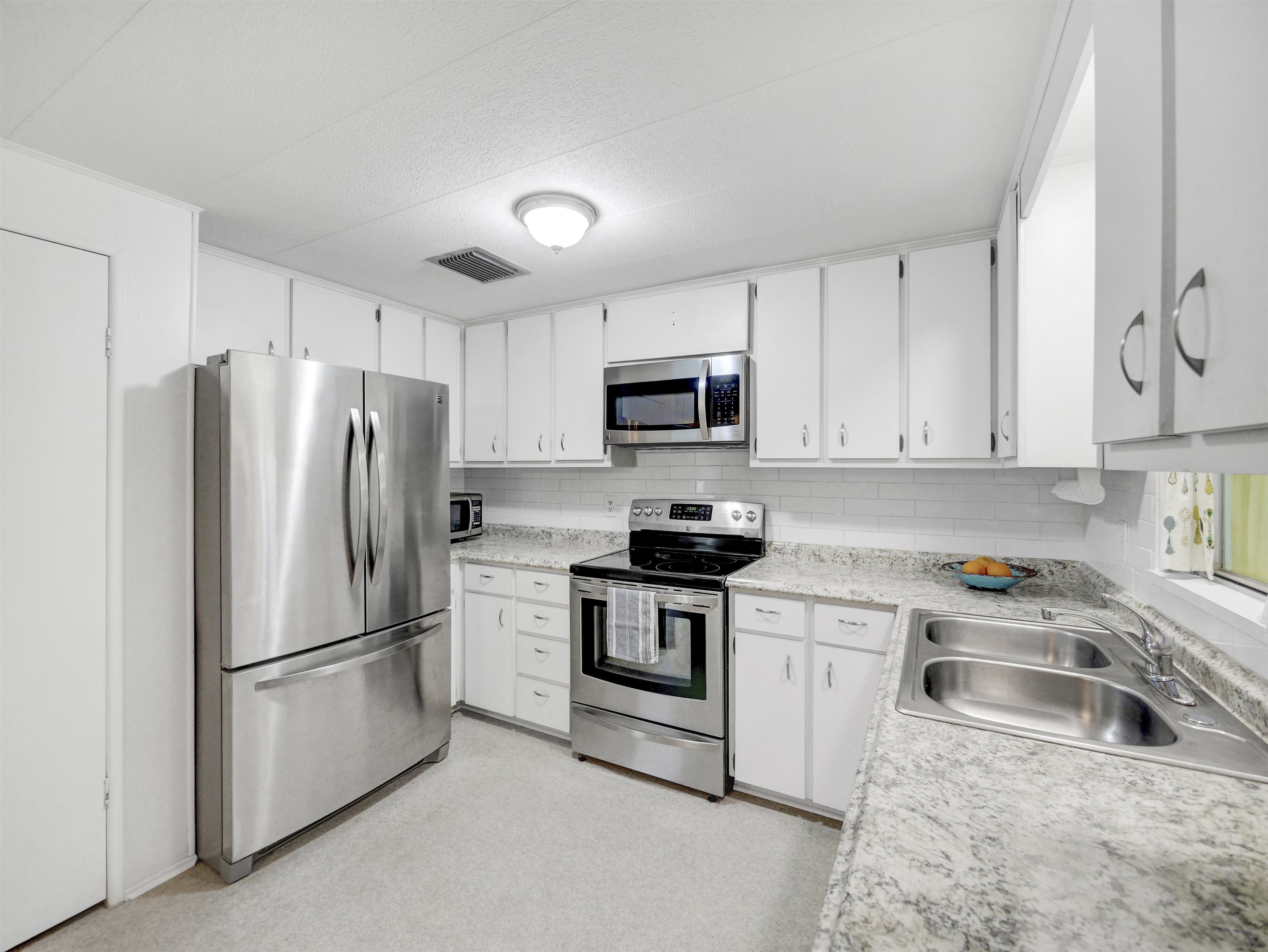 879 Palermo Road St. Augustine, FL 32086 - Photo 9 of 38 a kitchen with stainless steel appliances granite countertop a refrigerator sink stove and microwave
