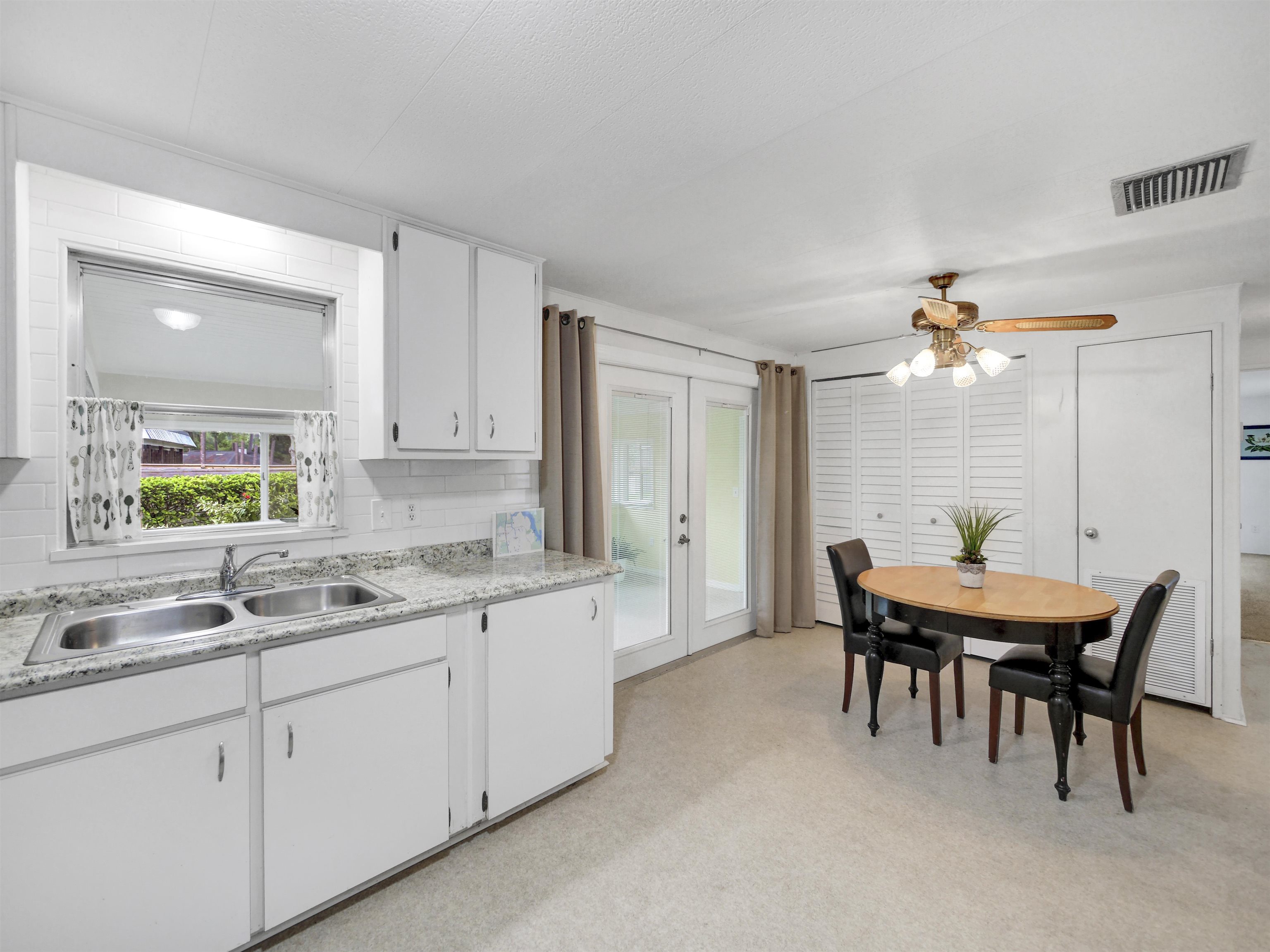 879 Palermo Road St. Augustine, FL 32086 - Photo 10 of 38 a kitchen with a dining table chairs and white appliances