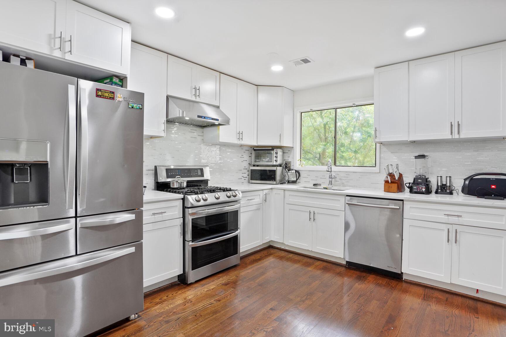 2412 Southgate Square Reston, VA 20191 - Photo 3 of 34 a kitchen with stainless steel appliances white cabinets a sink and a refrigerator