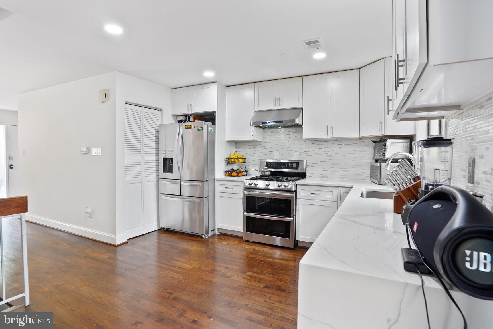 2412 Southgate Square Reston, VA 20191 - Photo 4 of 34 a kitchen with stainless steel appliances a refrigerator stove and wooden cabinets