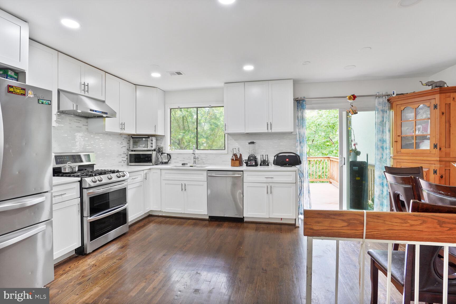2412 Southgate Square Reston, VA 20191 - Photo 5 of 34 a kitchen with a white cabinets a sink a window and stainless steel appliances