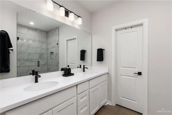 a bathroom with double sink and a mirror
